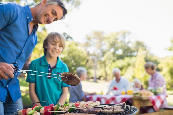 Father doing barbecue with his son