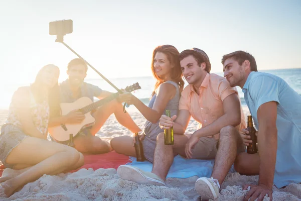 Happy hipsters taking pictures with selfie stick