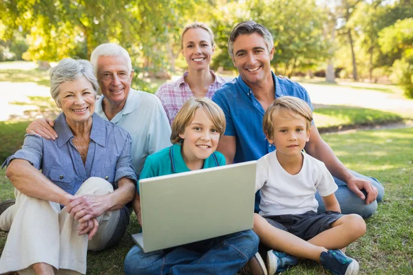 Happy family using laptop in park