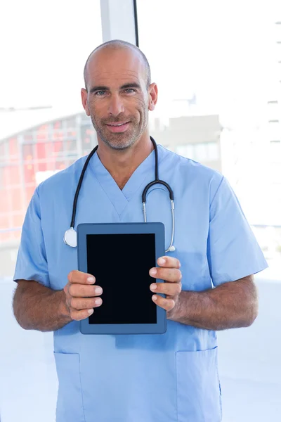 Smiling doctor holding tablet computer