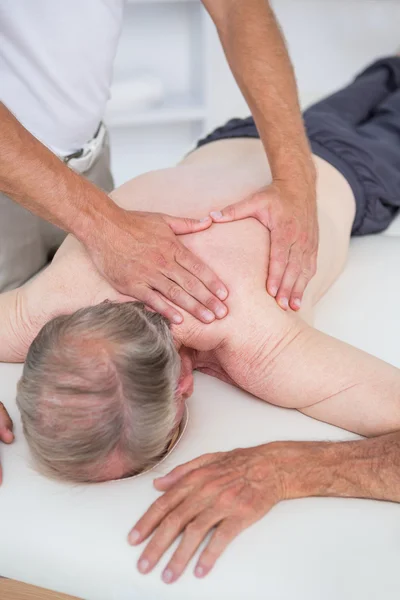Physiotherapist doing shoulder massage to patient