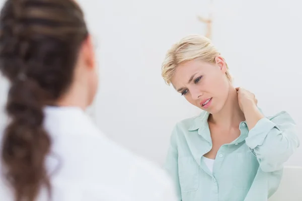 Patient with neck pain visiting doctor