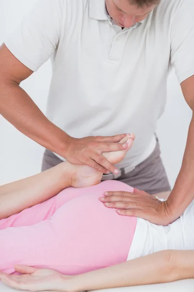 Physiotherapist doing leg massage to his patient