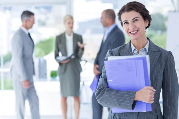 Smiling businesswoman holding files