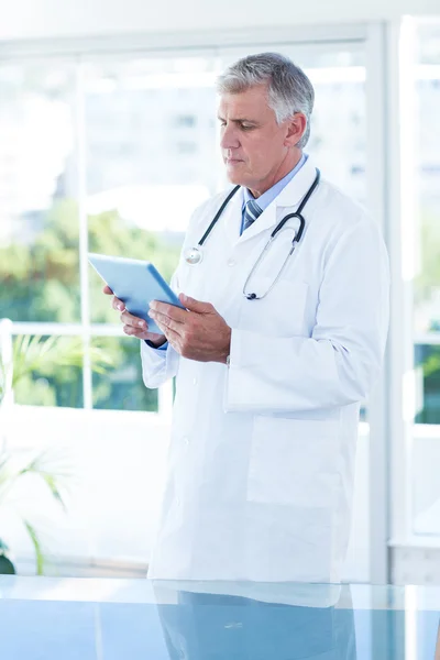 Concentrated doctor holding tablet