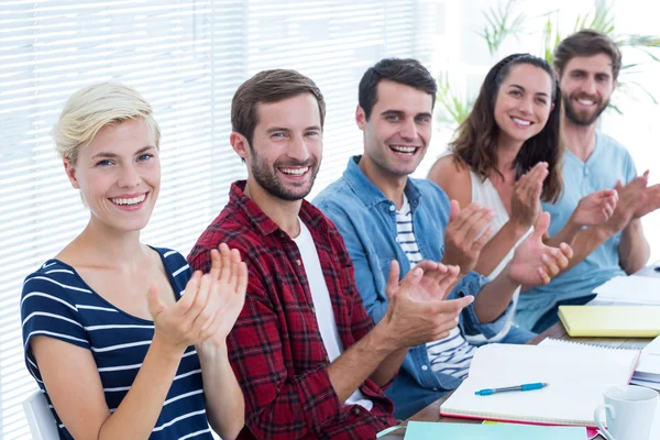 Colleagues clapping hands in meeting