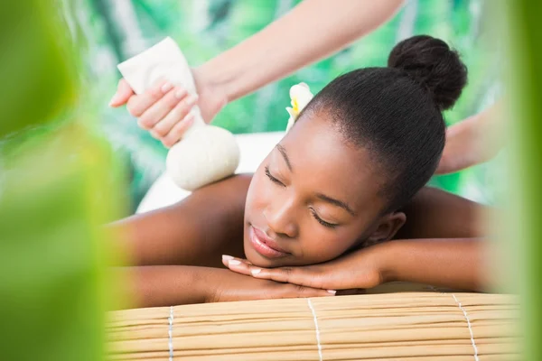 Woman enjoying herbal compress massage