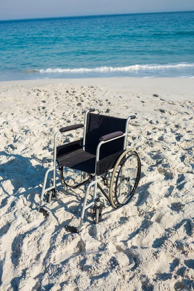 Black wheelchair on beach