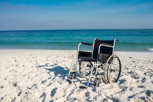 Black wheelchair on beach