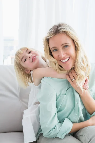 Mother sitting on couch with daughter