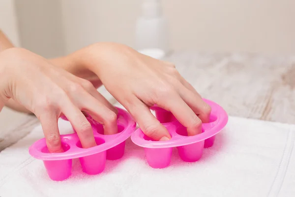 Woman soaking nails in nail bowls