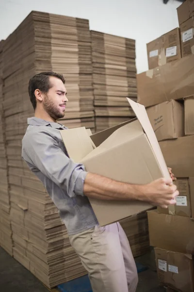 Worker carrying heavy box