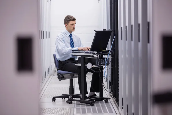 Technician using laptop to diagnose servers