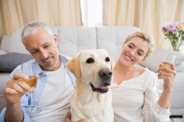 Couple with pet dog drinking champagne