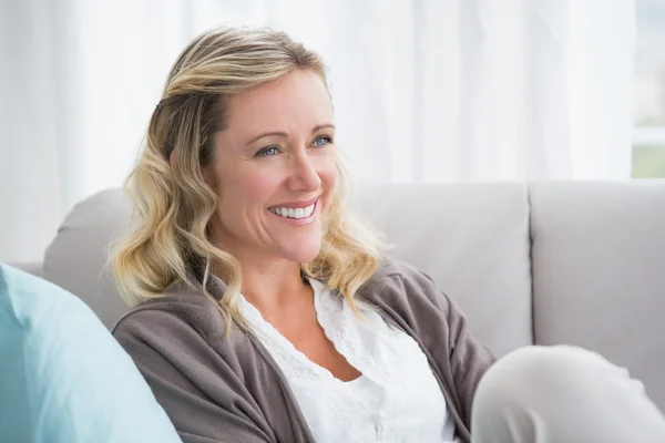 Woman day dreaming and sitting on couch