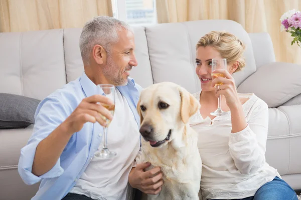 Couple with pet dog drinking champagne