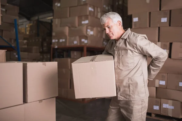 Worker with backache lifting box