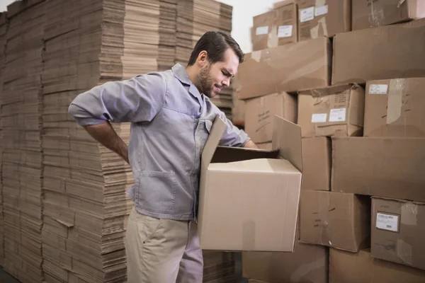 Worker carrying heavy box