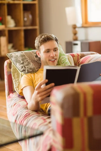 Man reading magazine on couch