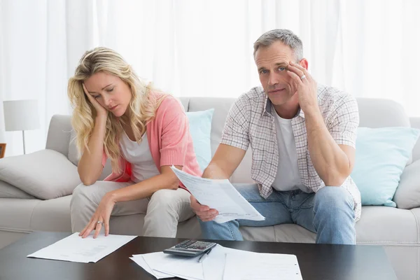 Couple calculating bills on couch