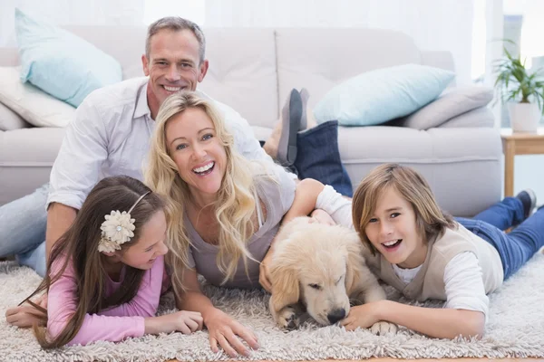 Family with yellow labrador on rug