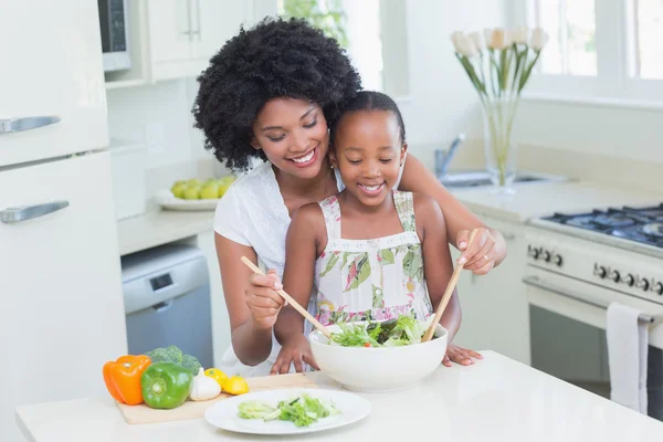 Mother and daughter making a salad together