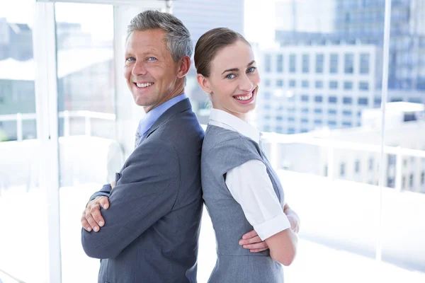 Two business colleagues standing back to back