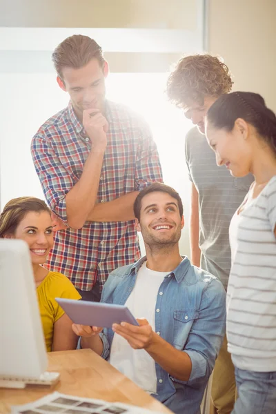 Creative business team gathered around a tablet