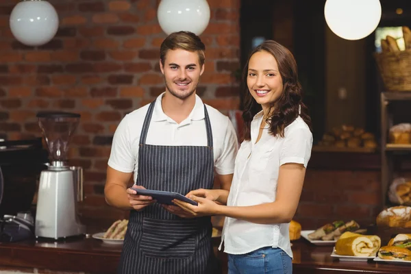 Smiling co-workers holding a tablet