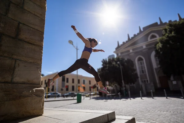 Athletic woman jumping off the stairs