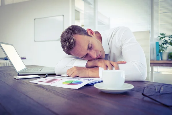 Exhausted businessman sleeping on desk