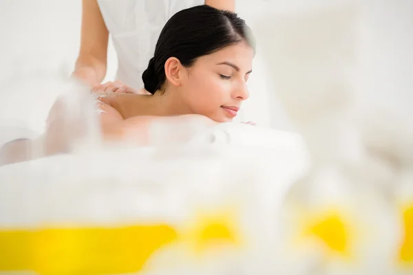 Woman enjoying a salt scrub massage