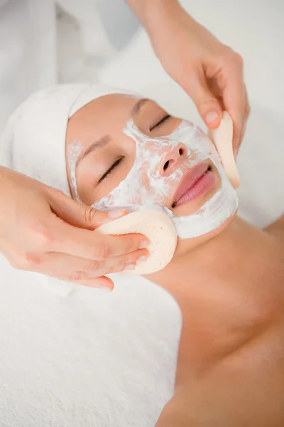 Hand cleaning womans face with cotton swabs