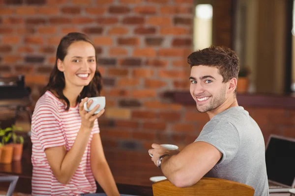 Smiling friends drinking coffee