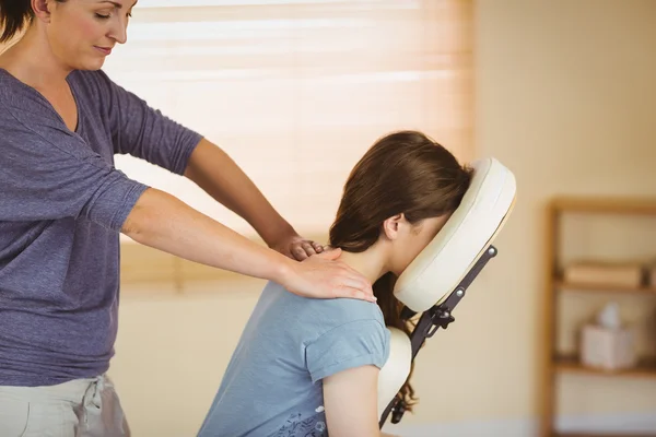 Young woman getting massage in chair