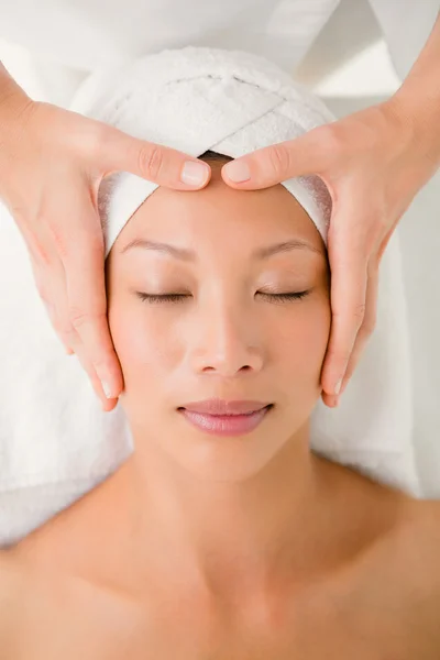 Young woman receiving forehead massage