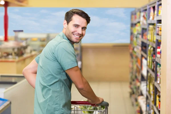 Portrait of smiling man pushing his trolley in aisle