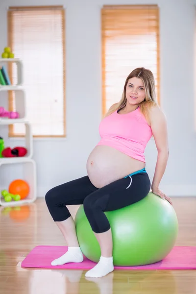 Pregnant woman sitting on exercise ball