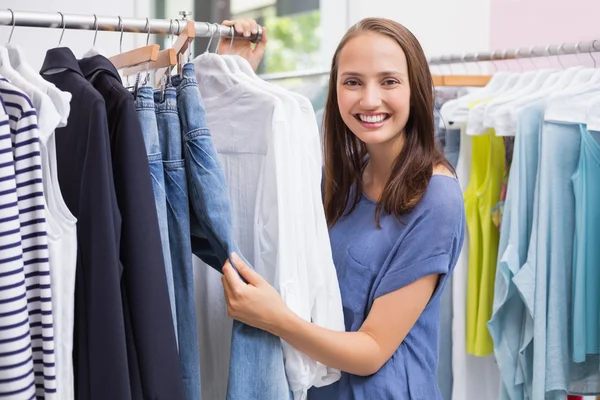 Pretty brunette browsing in the clothes rack