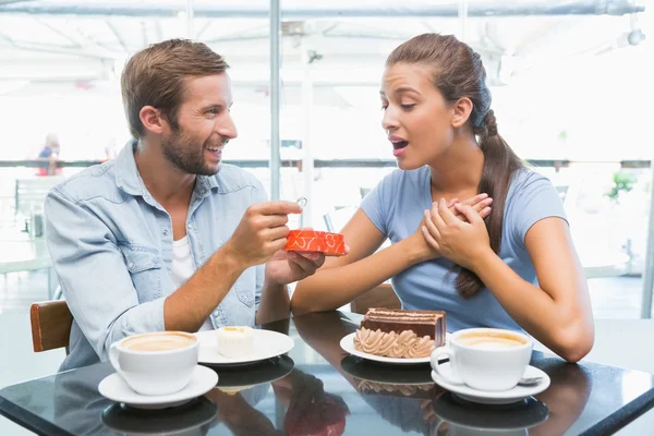 Couple eating cake and man giving ring