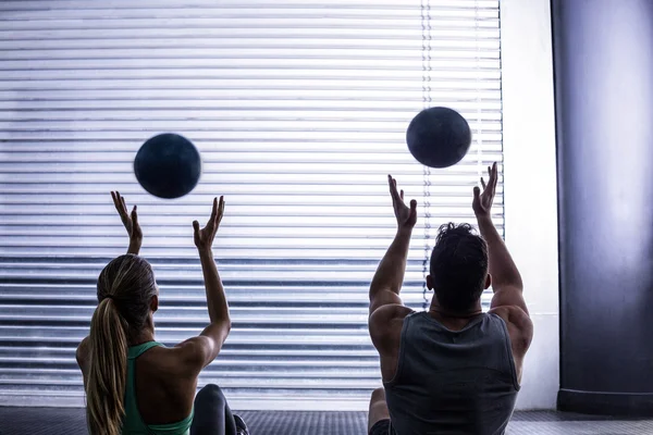 Muscular couple throwing ball in the air