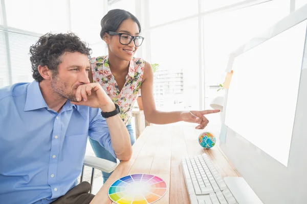 Casual couple using computer in office