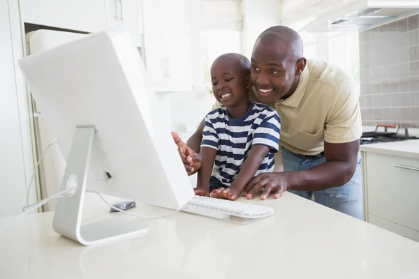 Happy smiling father with his son using computer