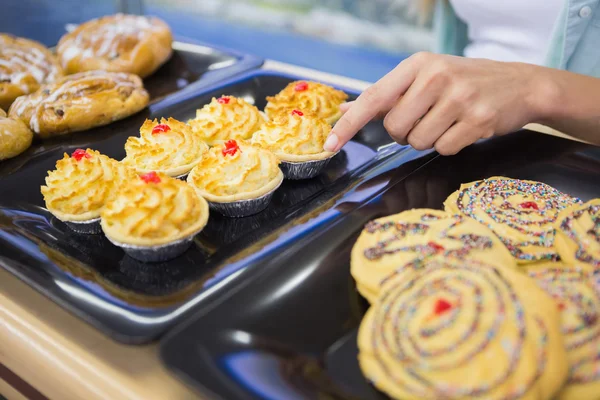 A baker presenting a new plates with pastries