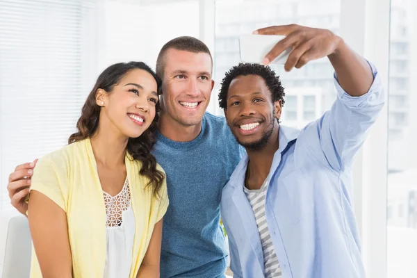 Smiling colleagues taking selfies