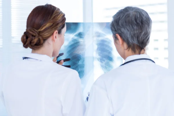 Concentrated medical colleagues examining x-ray tog