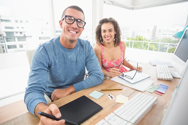 Smiling businessman using laptop and digitizer