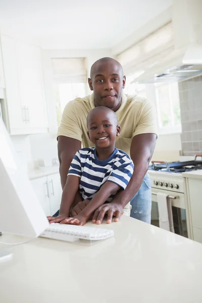 Happy smiling father with his son using computer