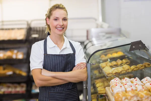 Portrait of a smiling blonde baker with arm crossed