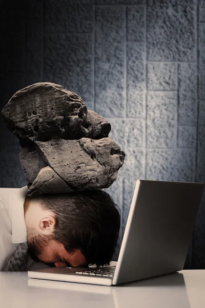 Businessman sleeping with stone on head